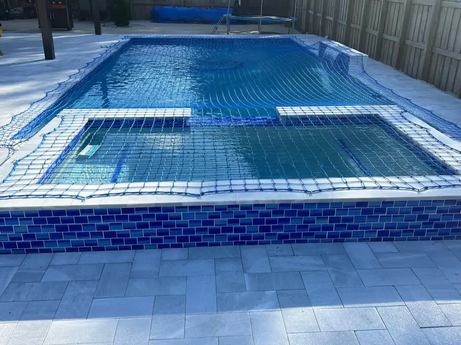 Blue brick-pattern tile on a spa wall beside a marble deck