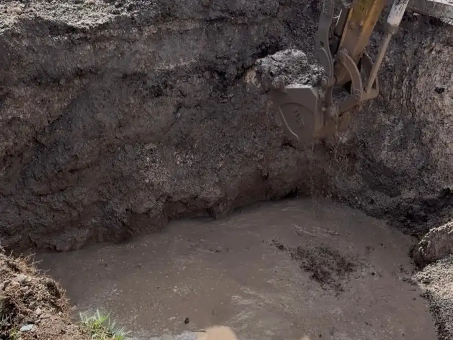 Excavator bucket working in a wet pool excavation